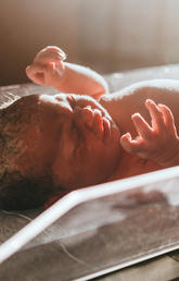A newborn baby in a bassinet