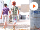 image of two kids walking in a refugee camp